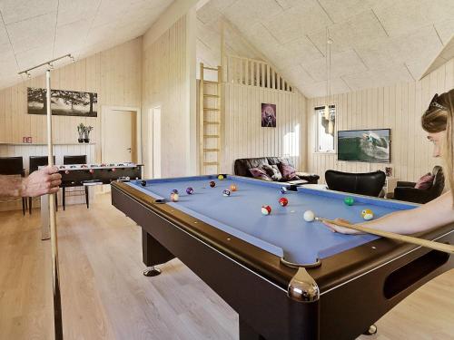 a woman playing a game of pool in a living room at Luxury Villa with Pool - By Traum Ferienwohnungen in Vejby