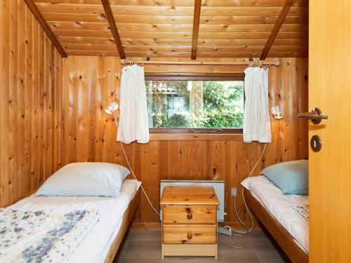 two beds in a wooden room with a window at Seaside Charm in Binderup-By Traum in Binderup Strand