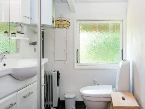 een badkamer met toilet, wastafel en raam bij Secluded Harbor Cottage-By Traum in Hemmet