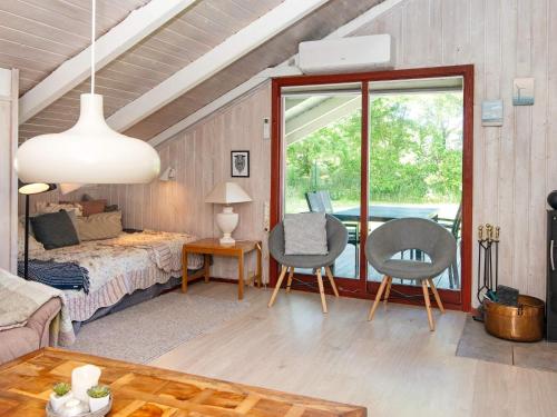 een kamer met een bed en twee stoelen en een tafel bij Secluded Harbor Cottage-By Traum in Hemmet