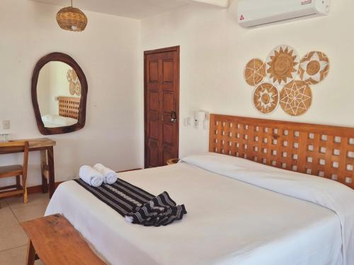 a bedroom with two beds and a mirror at Posada Ziga Playa in Mazunte