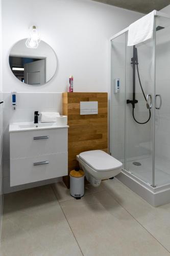 a bathroom with a shower and a toilet and a sink at Apartamenty Przystanek Morska in Gdynia