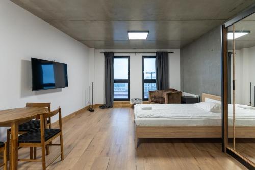 a bedroom with a bed and a table and a tv at Apartamenty Przystanek Morska in Gdynia