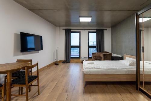 a bedroom with a bed and a table and a tv at Apartamenty Przystanek Morska in Gdynia