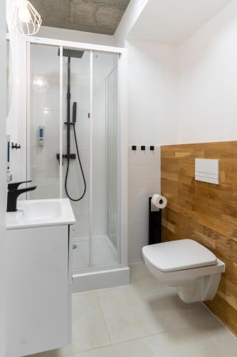 a bathroom with a shower and a toilet and a sink at Apartamenty Przystanek Morska in Gdynia