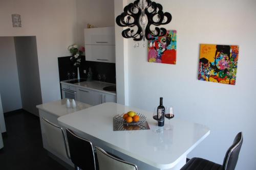 una cocina con una mesa blanca con un bol de fruta. en Luxury penthouse with sea view, en Makarska