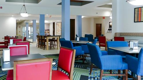 a waiting area with tables and chairs and tablesktop at Holiday Inn Express St. Petersburg North / I-275 by IHG in St. Petersburg