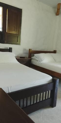 two beds in a room with at Finca Hotel los Nogales in Quimbaya