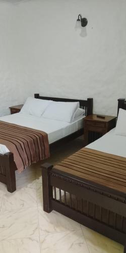 two beds sitting next to each other in a room at Finca Hotel los Nogales in Quimbaya