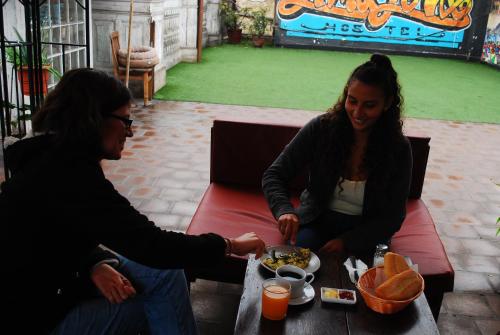 a man and a woman sitting at a table with a plate of food at 1900 Backpacker's Hostel in Lima
