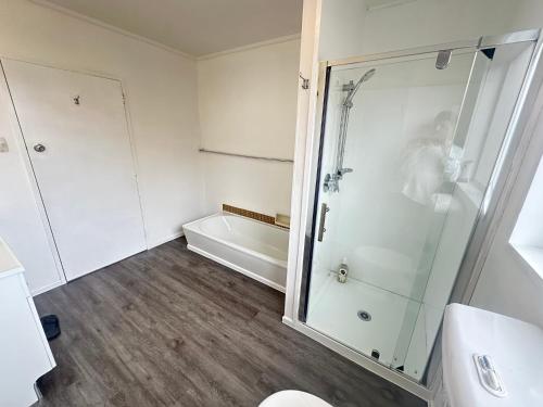 a bathroom with a shower and a toilet and a sink at Glenpark Lodge in Dunedin