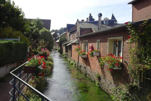 a narrow street with flowers on the side of buildings at Holiday Home near Alabaster Coast in Les Grandes-Ventes