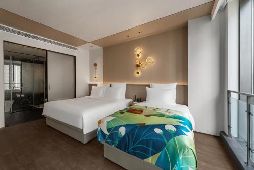 a bedroom with two beds and a bathroom at Novotel Kunshan East in Kunshan