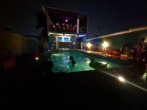 a group of people in a swimming pool at night at OSAK ROYAL GUEST House in Nsawam