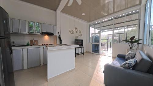 a kitchen with white cabinets and a couch in a room at Villa Cris Minca in Minca