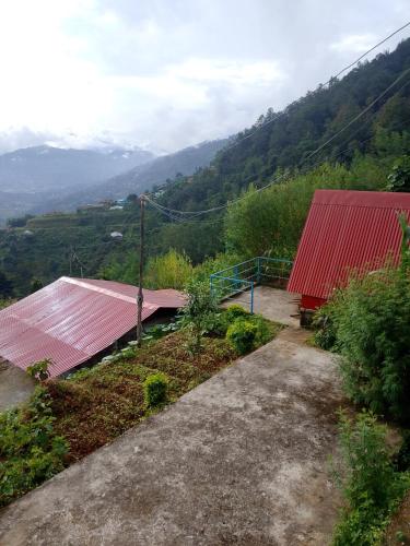 ドゥリケルにあるGaurishankar organic home stayの山の景色を望む赤い屋根の建物