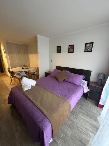 1 dormitorio con cama morada y mesa en Eventos y Conciertos I Movistar Arena, en Santiago