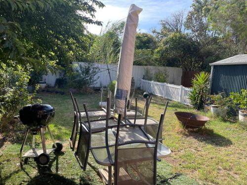 a grill and a chair in a yard at Home in Laverton 19 Minutes to Melbourne CBD in Laverton