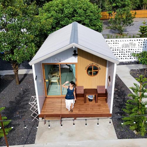 a woman standing in front of a tiny house at ชิลล์ แคมป์ ชะอม in Ban Bung Mai