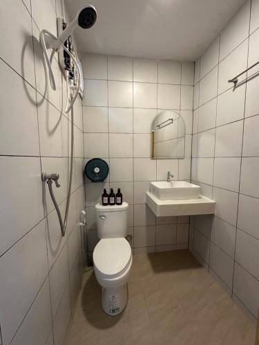 a bathroom with a toilet and a sink at ชิลล์ แคมป์ ชะอม in Ban Bung Mai