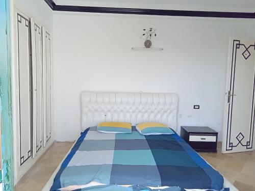 Un dormitorio con una cama con un edredón azul y blanco. en Hammam sousse, en Hammam Sousse