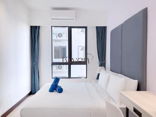 a bedroom with a white bed with a blue toy on it at KWEN Vetro11 - Charm of KK City in Kota Kinabalu