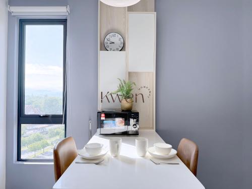 a white table with chairs and a microwave in a room at KWEN Vetro11 - Charm of KK City in Kota Kinabalu
