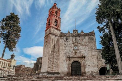 an old stone building with a clock tower on it at Casita de pueblo, Cercana a los Volcanes in Tlalmanalco de Velázquez