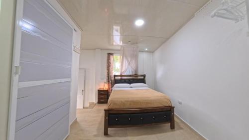 a bedroom with a bed in a white room at Villa Cris Minca in Minca