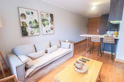 a living room with a couch and a table at HOM I Depto con Gran Terraza con Vista al Lago in Puerto Varas