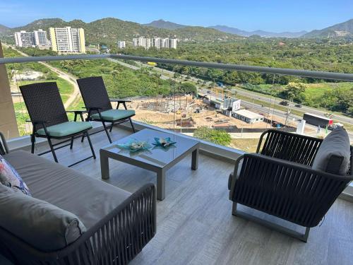 a balcony with a couch and chairs and a table at Apartamento espectacular Santa Marta in Santa Ana