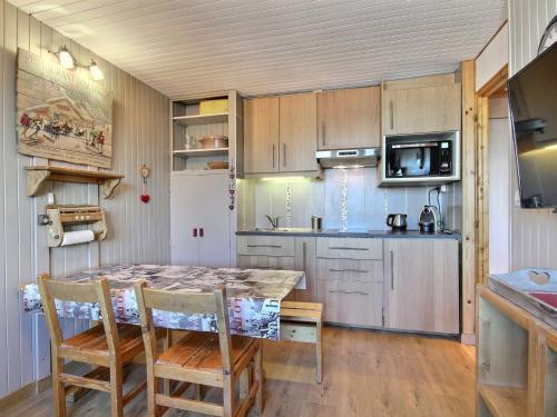 a kitchen with a table and chairs in a room at Charmant 2 pièces à La Plagne, animaux admis - FR-1-455-273 in La Plagne Tarentaise