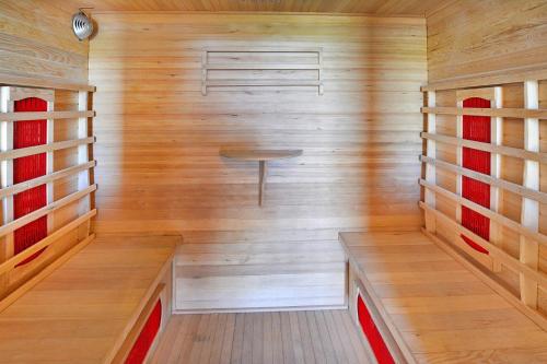 a small sauna with wooden walls and a bench at Holiday Home by Lake Jamno with Pool in Osieki