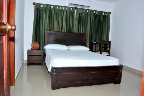 a bedroom with a bed with a green curtain at CasaHotel Linda V in Montería