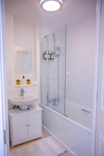 a white bathroom with a shower and a sink at Mory Homes Modern 2 BDR Flat Private Parking in Central MK in Milton Keynes