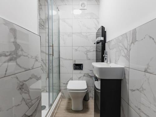 a bathroom with a toilet and a sink at Leicestershire Aparthotels - Field Street Court in Shepshed