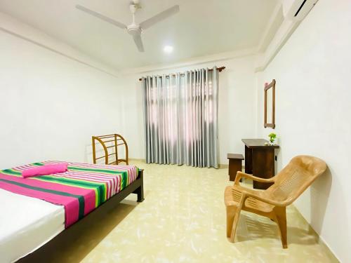 a bedroom with a bed and a chair and a desk at Akee villa in Matara