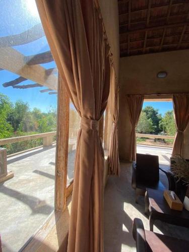 a room with a large window with a curtain at HappyZen Farm in Vung Tau