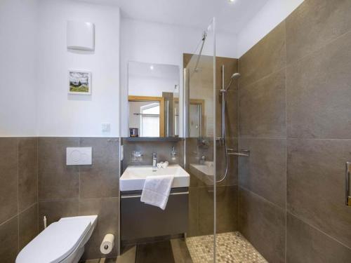 a bathroom with a shower and a sink and a toilet at Stylish Chalet by Ski Slopes in Neukirchen am Großvenediger