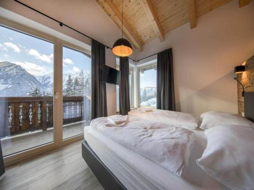 ノイキルヒェン・アム・グロースヴェンエーディガーにあるChalet near Wildkogel Arenaのベッドと大きな窓のある寝室