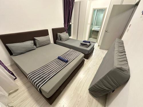 two beds and a couch in a room at SA Sutera Avenue Homestay - Kota Kinabalu Area KK City Opposite Imago in Kota Kinabalu