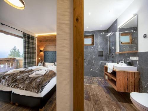 a bedroom with a large bed and a bathroom at Ski-Friendly Chalet in Neukirchen in Neukirchen am Großvenediger