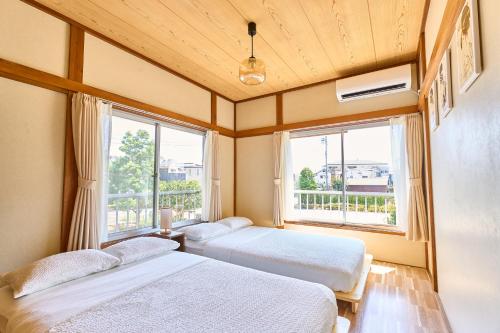two beds in a room with a window at Stay as Local mizue in Tokyo