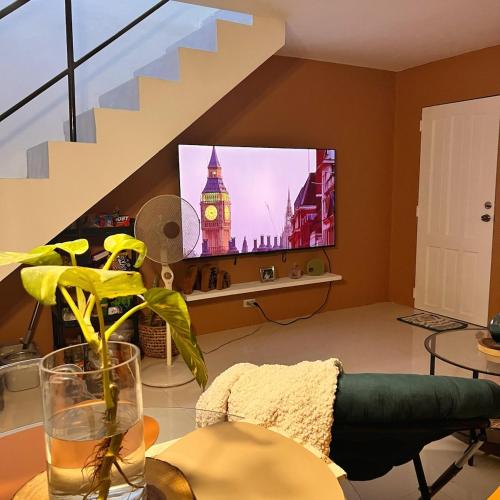 a living room with a tv and a staircase at RQ Pool Villa - 2 in Sampong