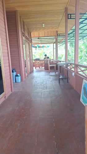 an empty porch of a house with tables and chairs at Raja Ampat Koba-koba Guest House in Waisai