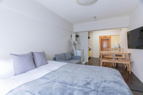 Un dormitorio con una cama grande y una silla. en Uburu Apartment, en Fukuoka