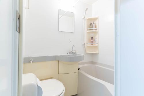 Un baño con inodoro, lavabo y bañera. en Uburu Apartment, en Fukuoka