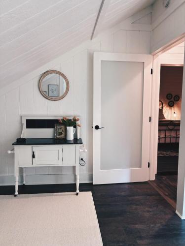a white room with a white door and a mirror at Hidden Meadow - rustic hideaway in Aubrey
