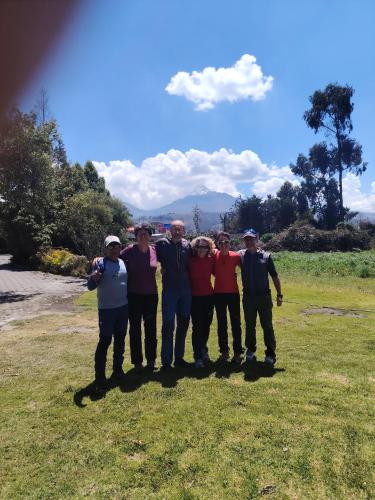 a group of people posing for a picture in a field at Centro de Aclimatizacion La Casa de Simon Lodge in Toacazo