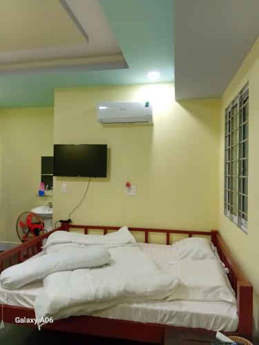 a bedroom with a bed with a air conditioner on the wall at HOTEL MOTeL ĐỒNG KHỞI in Ben Tre